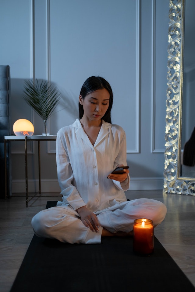 woman meditating with candle