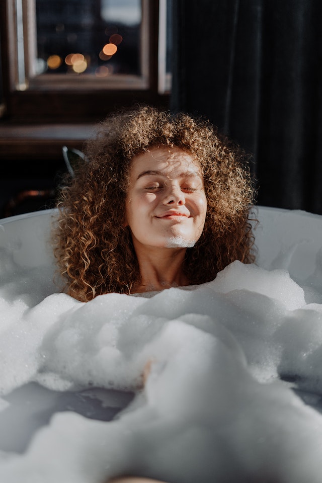 woman smiling in bubble bath