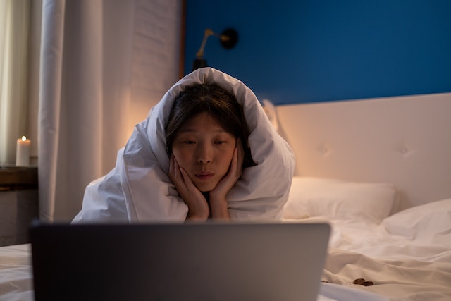 Woman watching film on bed