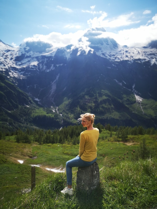 woman perched on rock inspired by mountain scenary
