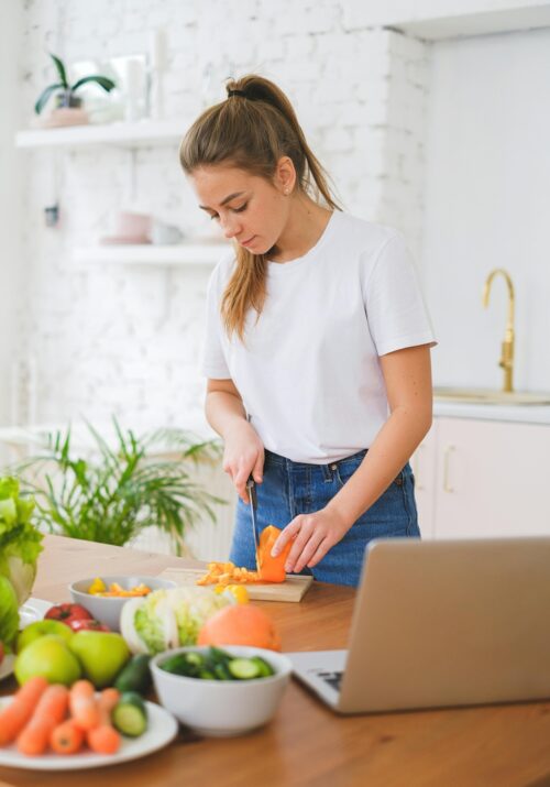 Young woman doing her meal prepping for the week after looking at meal prep ideas for busy professionals