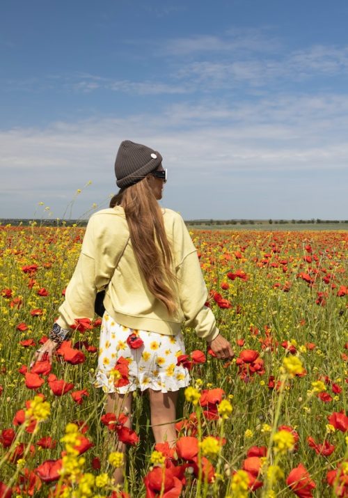 woman romanticizing life standing in poppy field