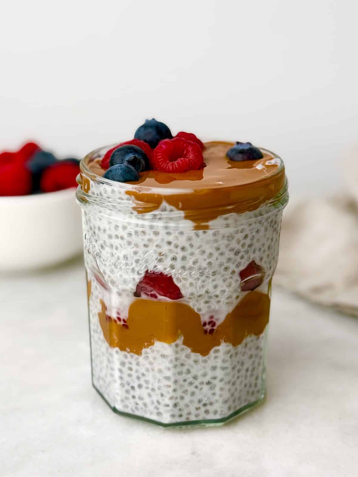 Chia seed pudding layered with peanut butter, blueberries, and raspberries
