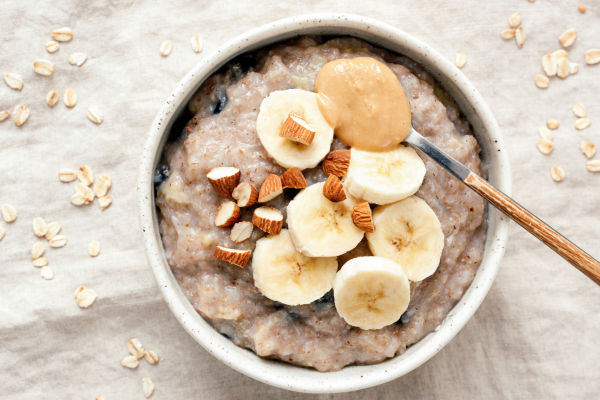 High protein oatmeal topped with banana slices, almonds, and peanut butter.