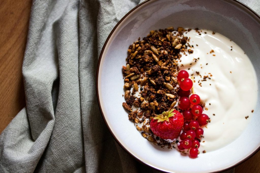 High protein low carb breakfast with yogurt, granola, and fresh berries.