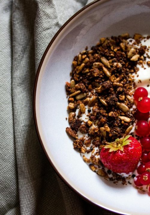 High protein low carb breakfast with yogurt, granola, and fresh berries.