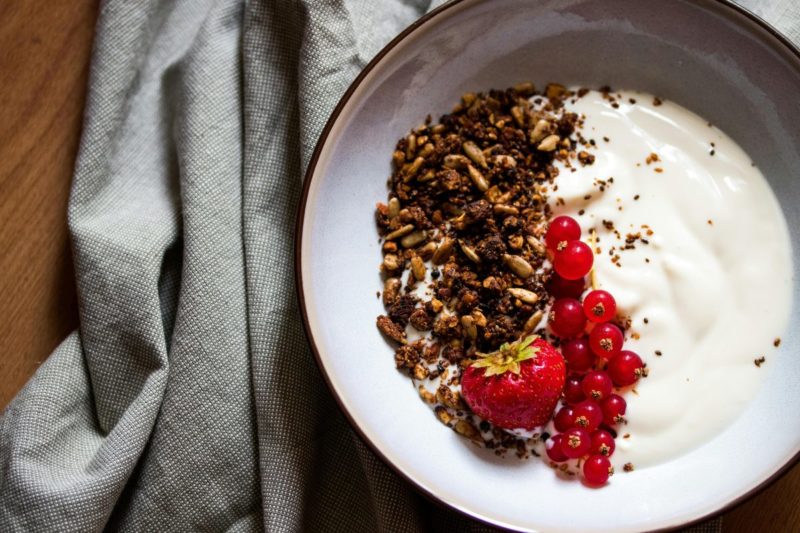 High protein low carb breakfast with yogurt, granola, and fresh berries.