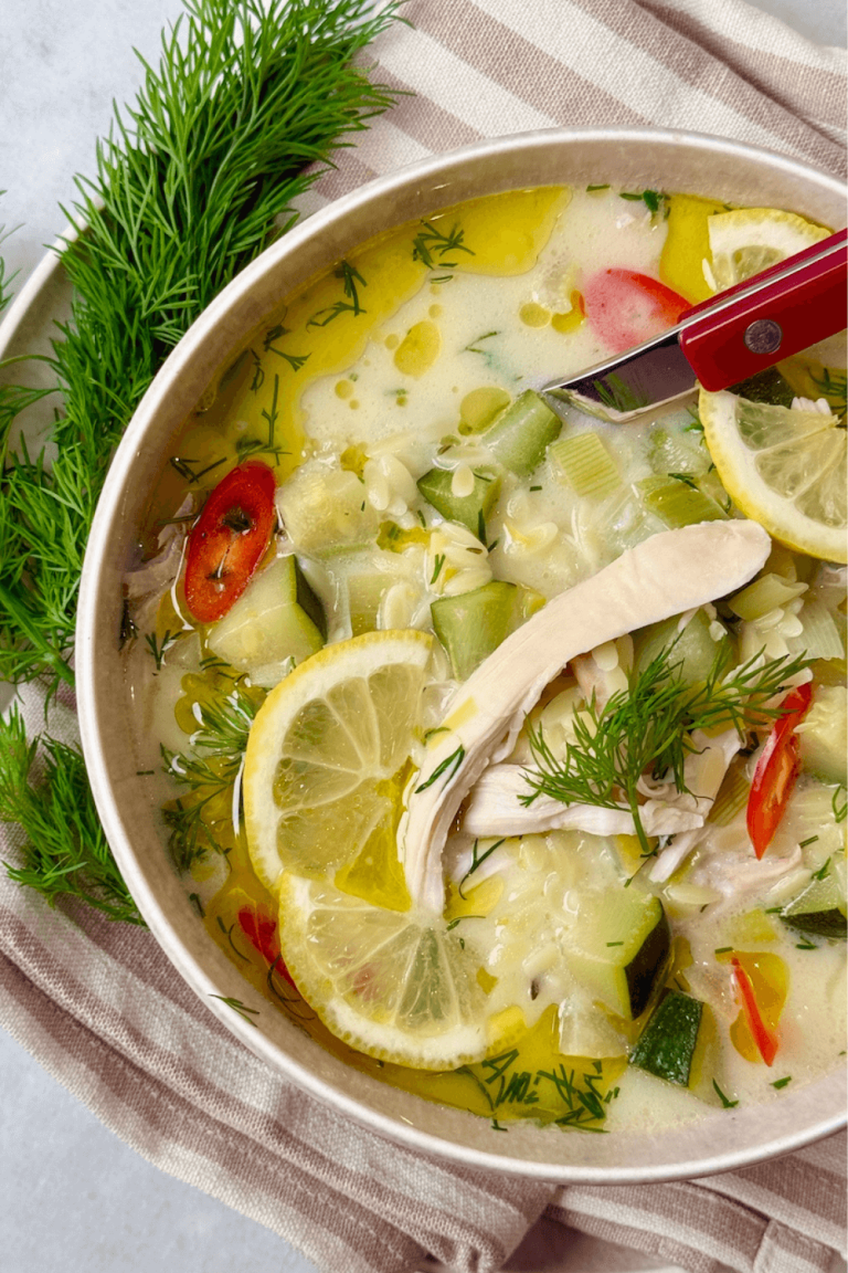 Healthy lemon chicken orzo soup with fresh dill, zucchini, and red chili in a creamy broth, served in a white bowl – healthy soup recipe.