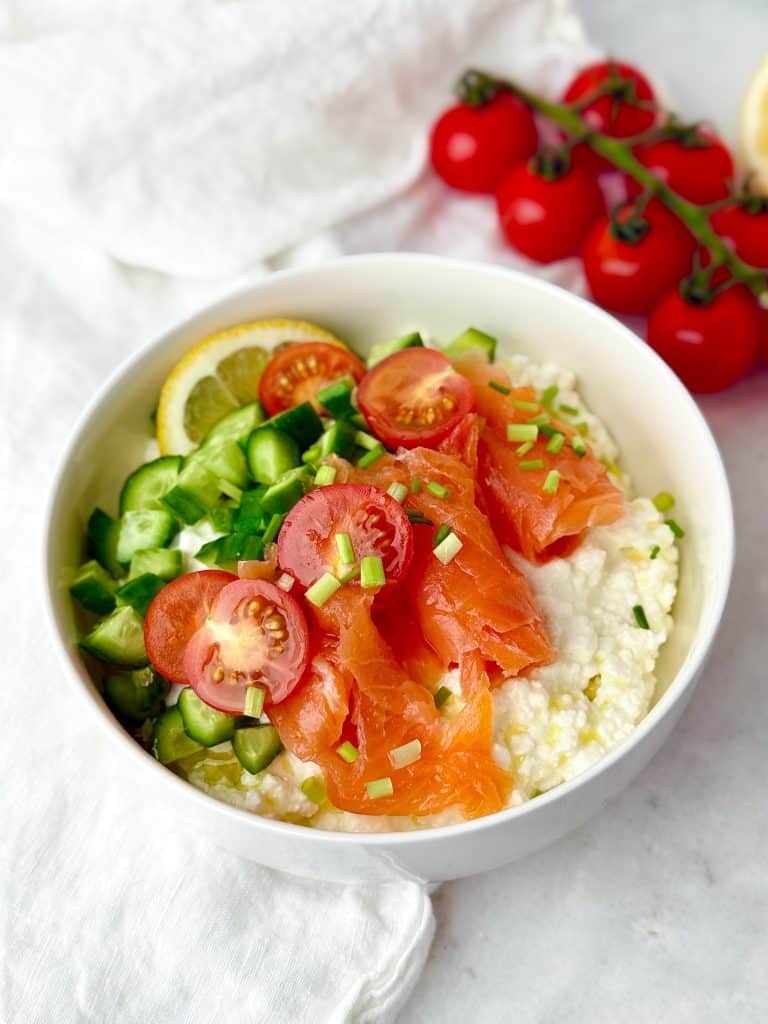 Savory high-protein cottage cheese bowl topped with smoked salmon, diced cucumber, cherry tomatoes, and fresh chives