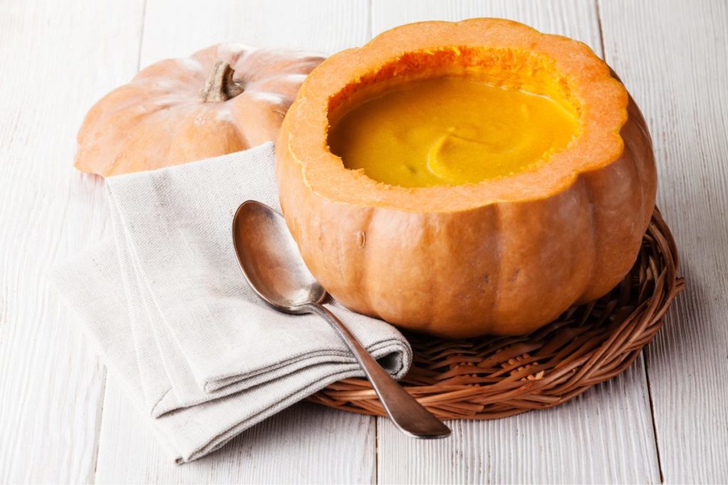 Creamy pumpkin soup served in a carved-out pumpkin bowl, a perfect addition to pumpkin recipes for fall.