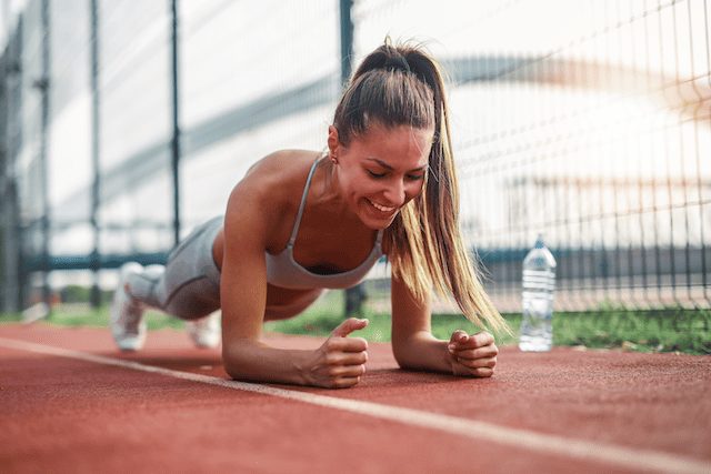 Woman in a forearm plank position, strengthening her deep core muscles.