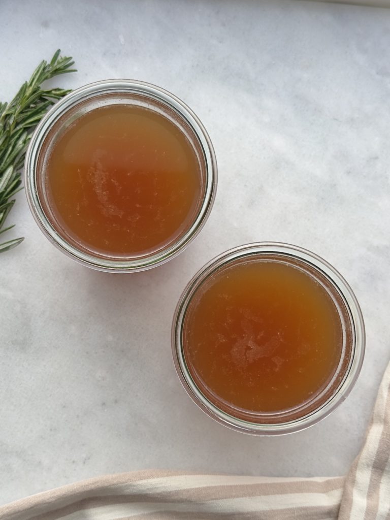 crockpot bone broth recipe in two glass jars