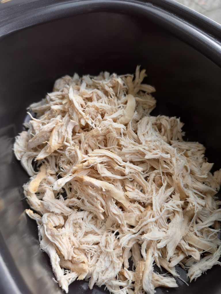 Crockpot shredded chicken in a slow cooker.