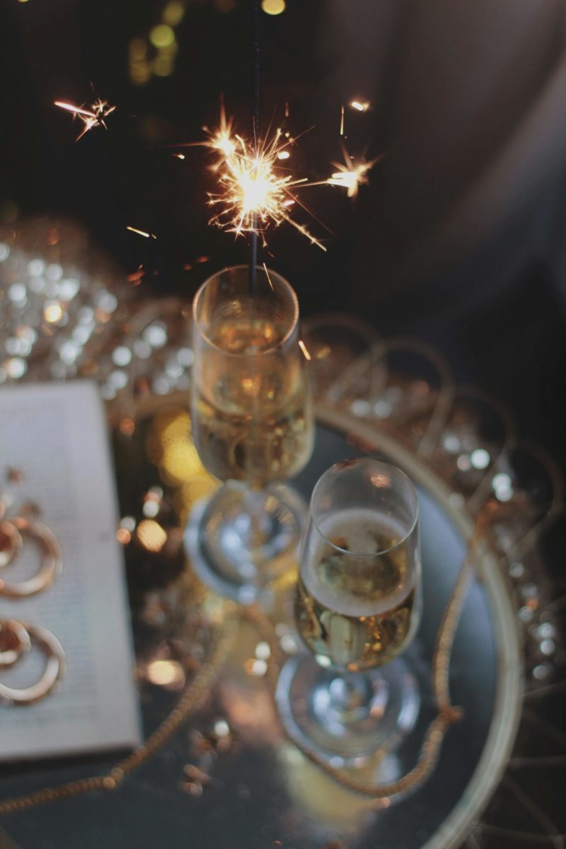 New Year resolution ideas represented through two glasses of champagne and a sparkler