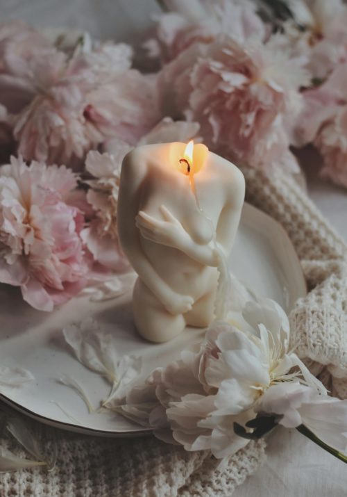 A candle shaped like a woman's body representing cycle syncing.