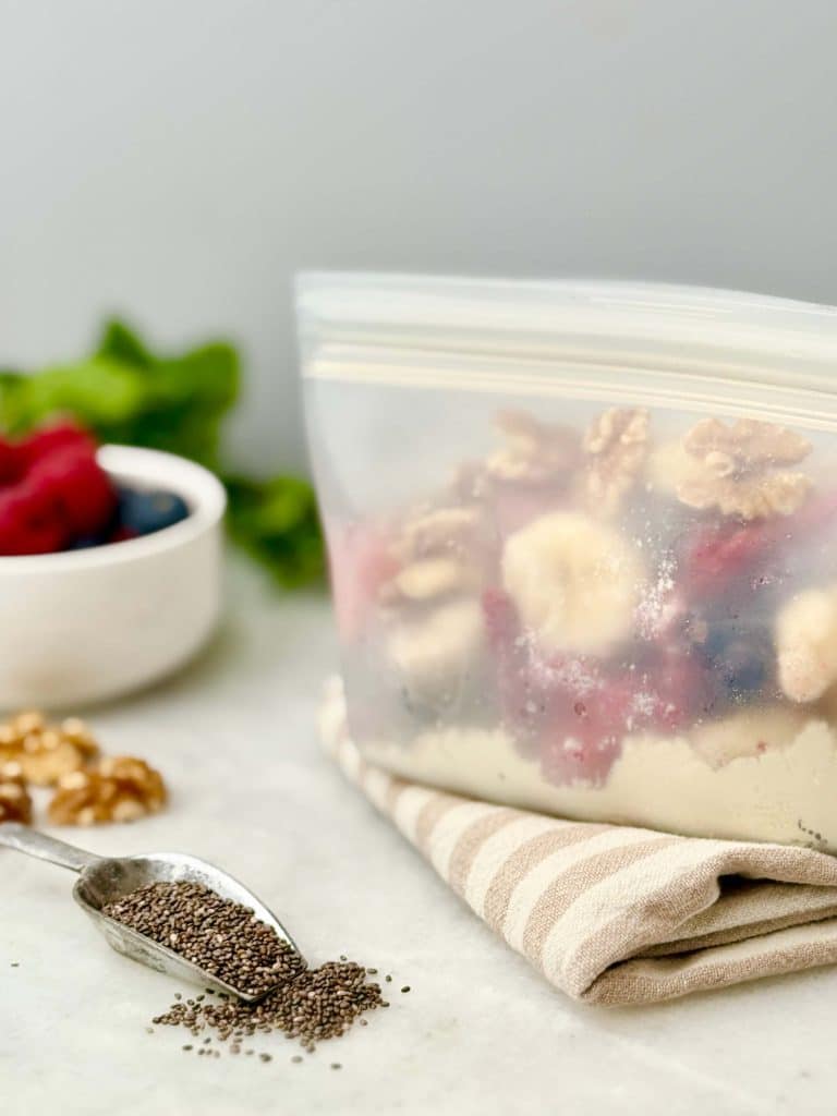 DIY smoothie freezer pack with protein powder, berries, nuts, and chia seeds for easy 30 grams protein breakfast prep.