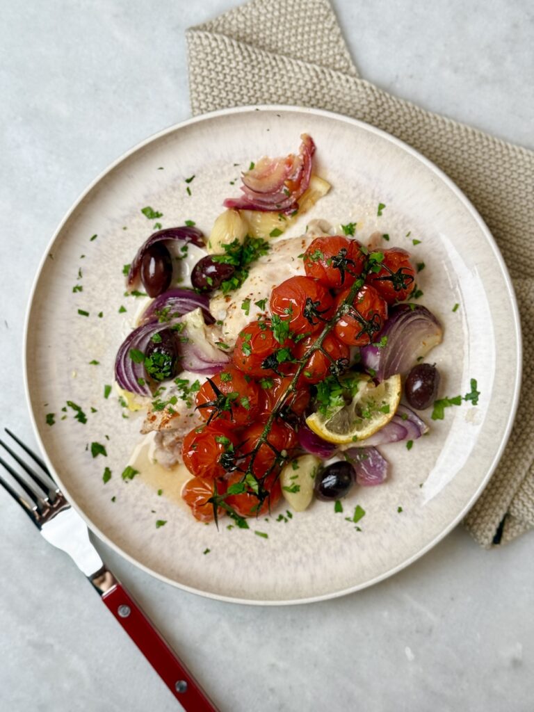 plated dinner of chicken thighs olives and lemon