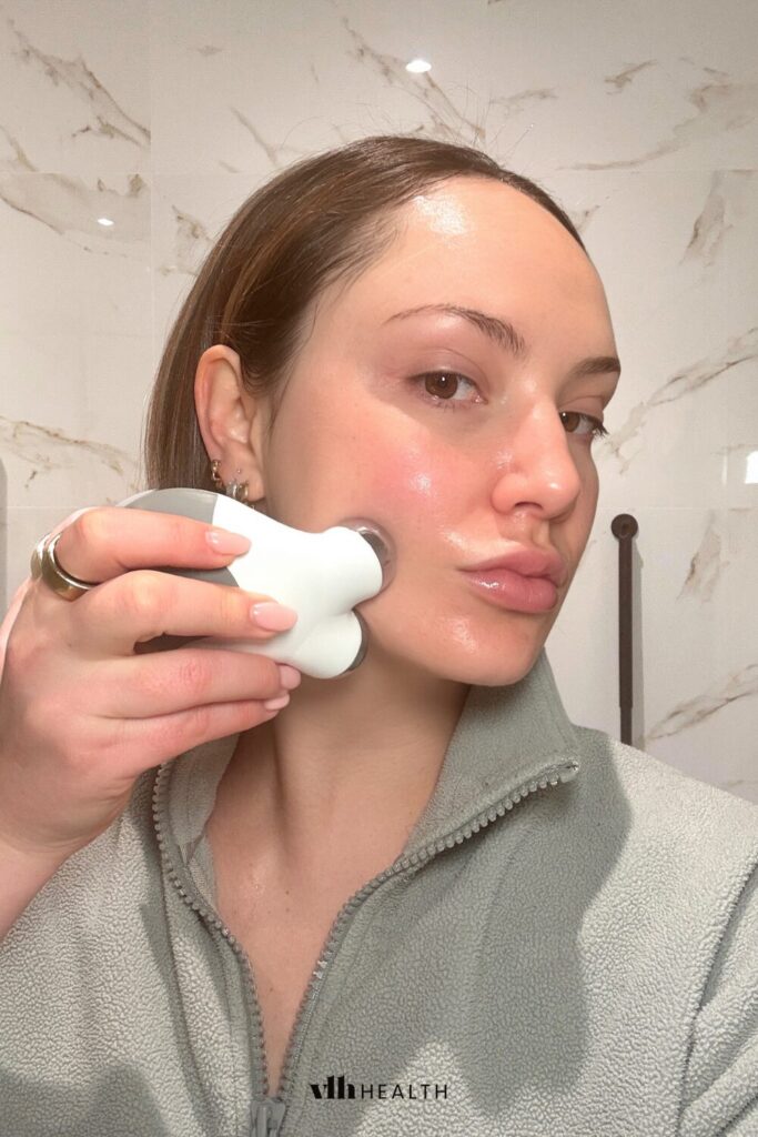 Woman using a microcurrent device on her cheekbone for a lifted, sculpted facial appearance.