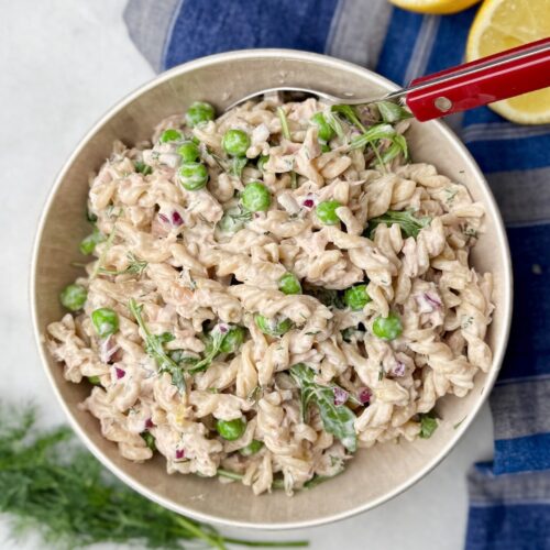 Creamy high-protein tuna pasta salad with peas, red onions, fresh dill, and a light dressing.