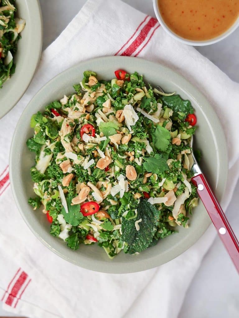 Houston's kale salad recipe topped with crushed peanuts, shaved parmesan, and cilantro