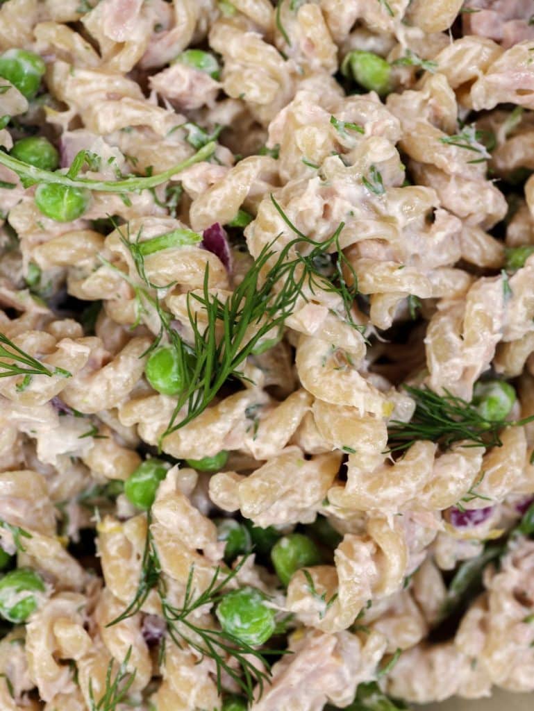 Macro shot of low calorie high protein tuna pasta with whole wheat fusilli, peas, and fresh dill