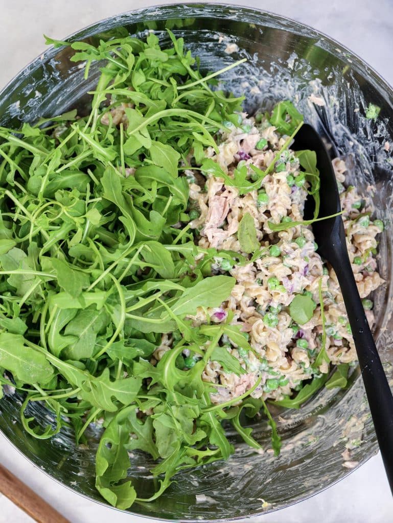 High-protein tuna pasta salad with fresh arugula added before serving