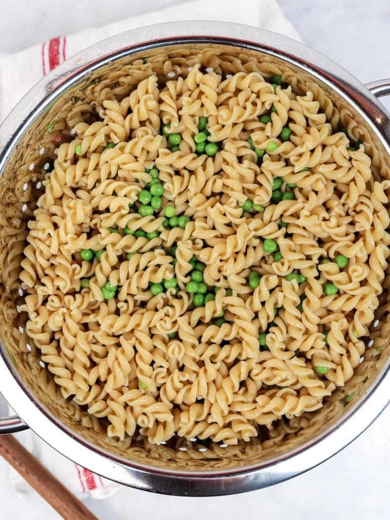 Drained whole wheat pasta and green peas for protein tuna pasta salad