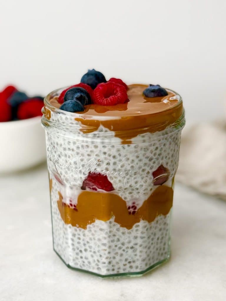 Chia seed pudding layered with berries and caramel in a jar