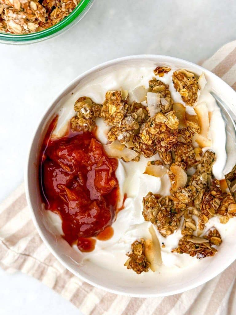 Greek yogurt bowl topped with protein granola and strawberry jam