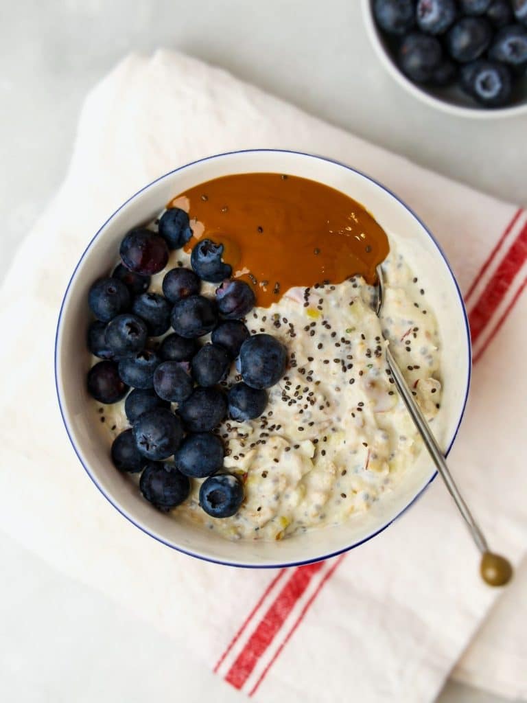 Bircher muesli bowl with raspberries, seeds, and honey drizzle