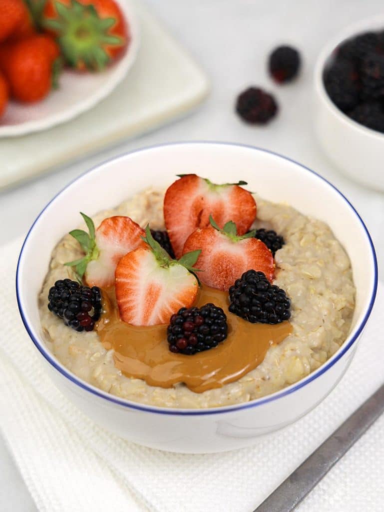 High-protein breakfast oatmeal with peanut butter, strawberries and blackberries