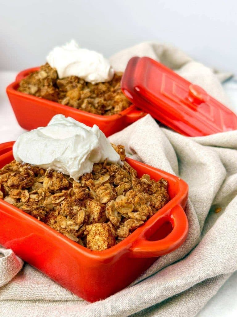 Protein apple crisp in red ramekins topped with Greek yogurt