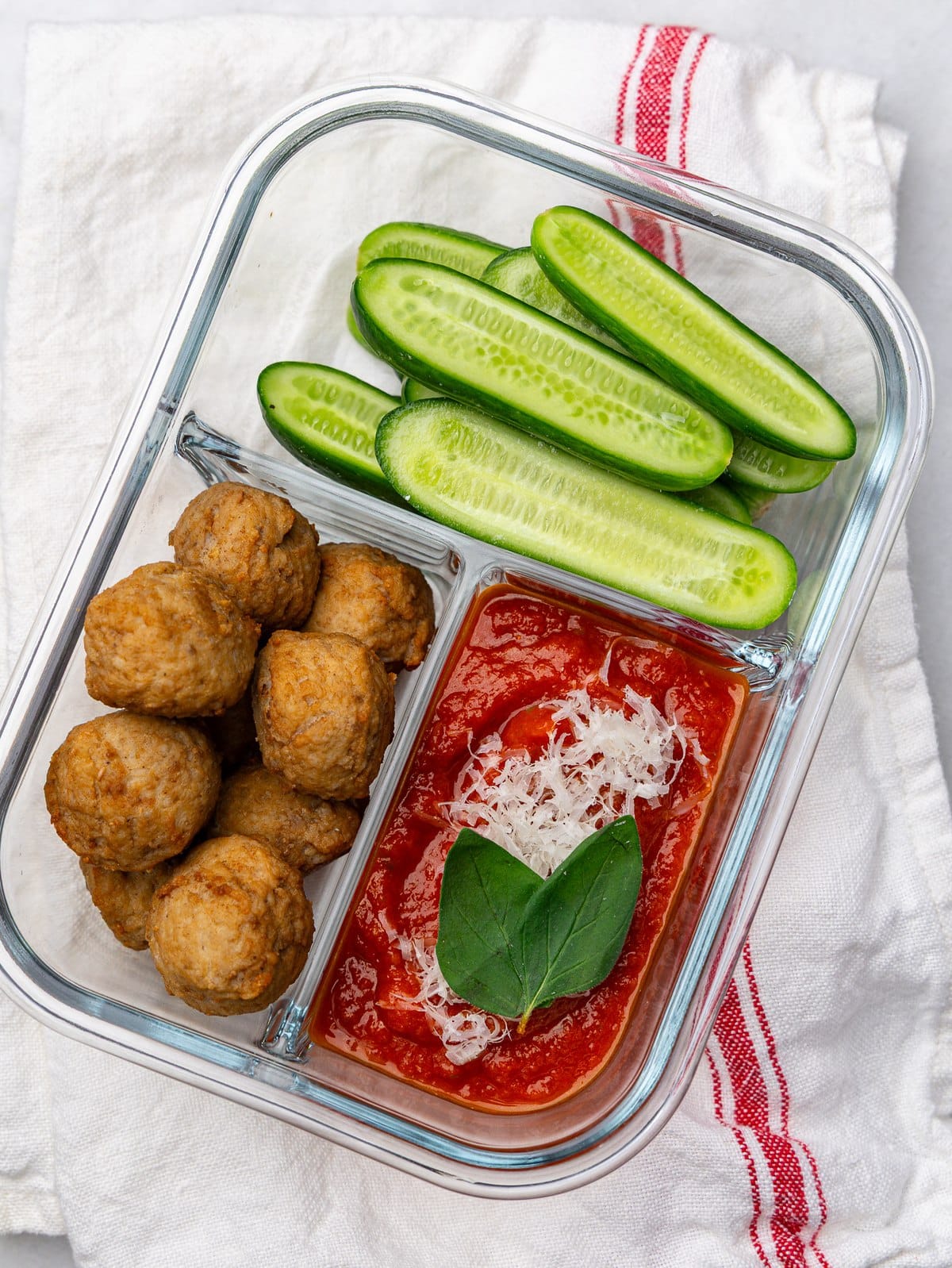 Turkey meatball lunch box with marinara dip and cucumber spears