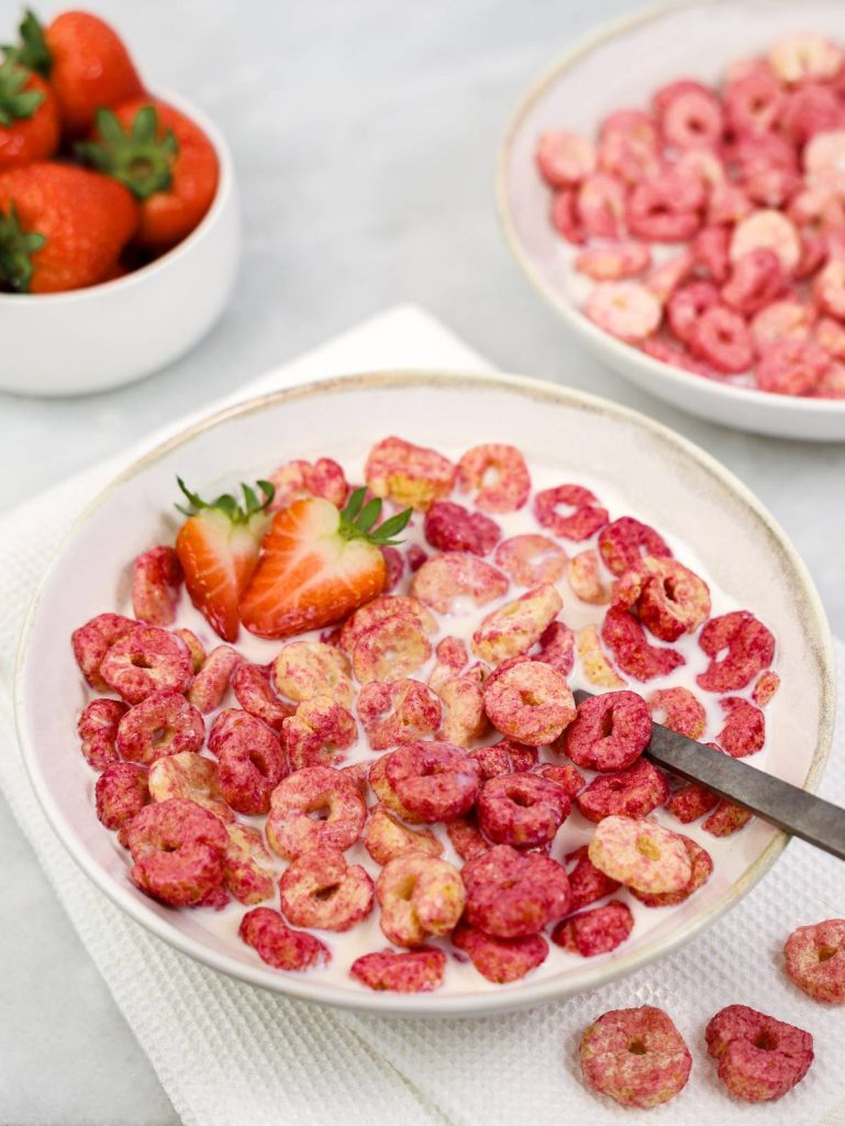 High-protein strawberry breakfast cereal in milk with fresh strawberry halves