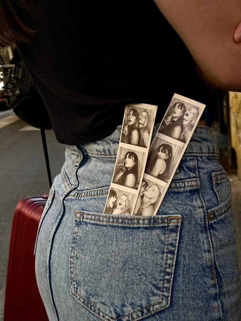 two friends with photo booth pictures tucked into jeans pocket, symbolizing habits that strengthen relationships