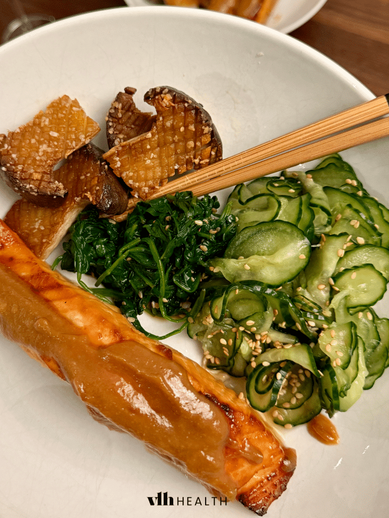 Oven-baked salmon fillet with a rich miso glaze, served with sautéed spinach, cucumber salad, and roasted mushrooms. A perfect low-carb high-protein dinner idea.