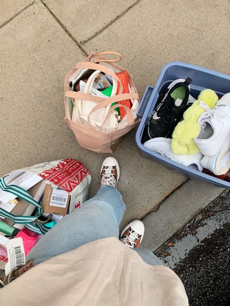a person donating shoes and household items in reusable bags, representing sustainable and minimalism habits