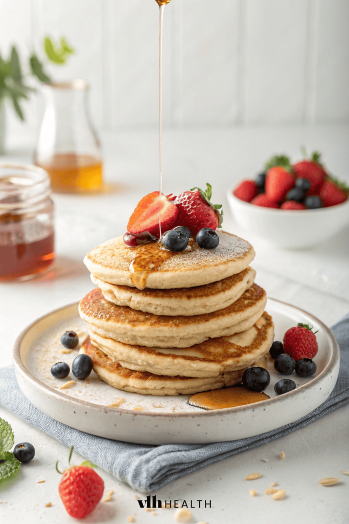 Stack of protein pancakes topped with berries and maple syrup
