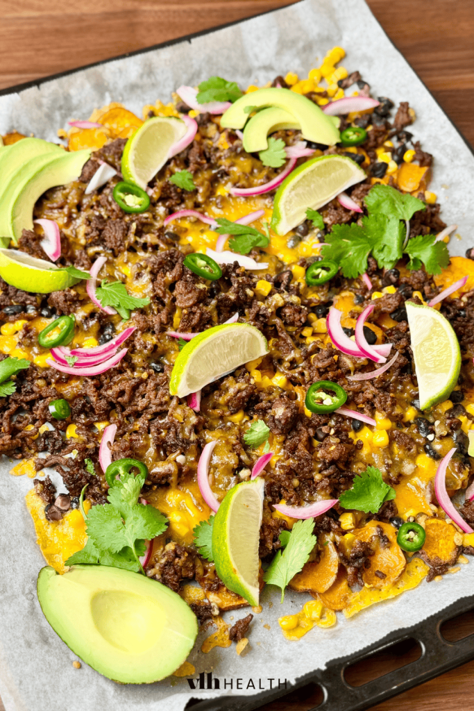 Loaded sheet pan nachos with ground beef, avocado, and lime