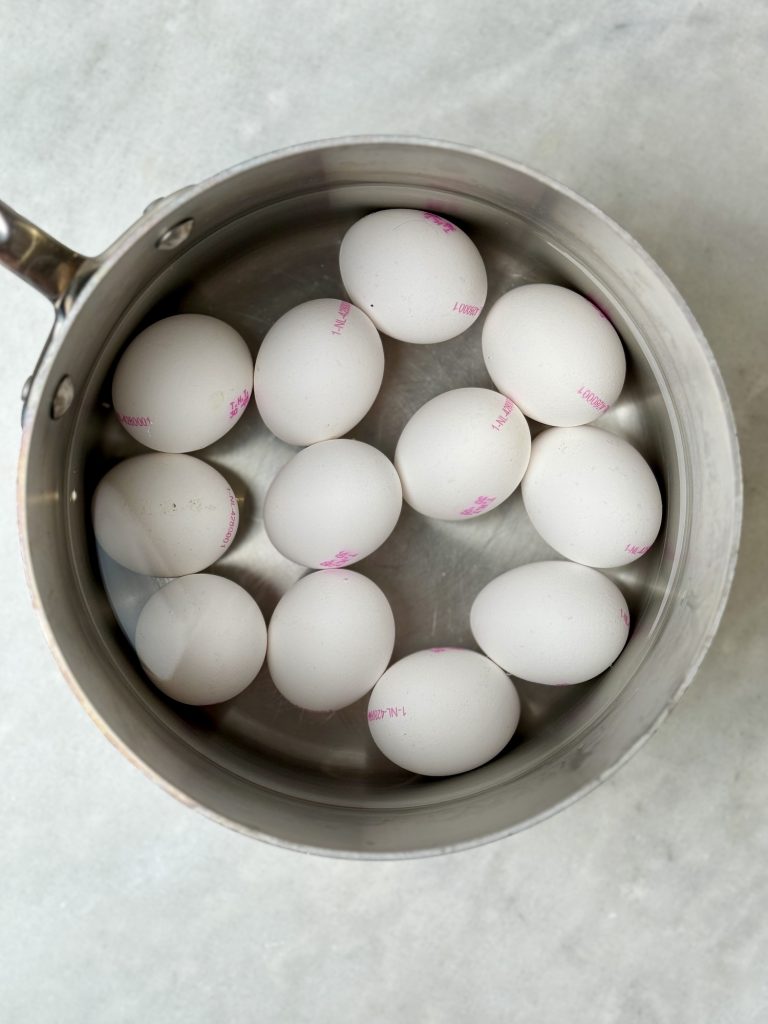 Uncooked eggs in a saucepan filled with cold water, ready to bring to a boil for egg salad