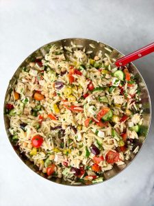 Fully mixed Greek chicken and orzo pasta salad with tender orzo, crisp veggies, marinated feta, and lemony grilled chicken, perfect for summer meals or meal prep.