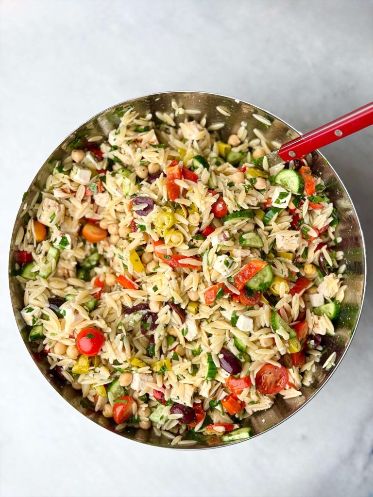 Fully mixed Greek chicken and orzo pasta salad with tender orzo, crisp veggies, marinated feta, and lemony grilled chicken, perfect for summer meals or meal prep.