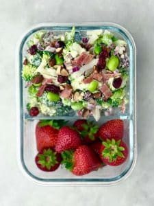 Healthy high protein broccoli salad shown in a stainless bowl after mixing, with creamy dressing coating all ingredients.