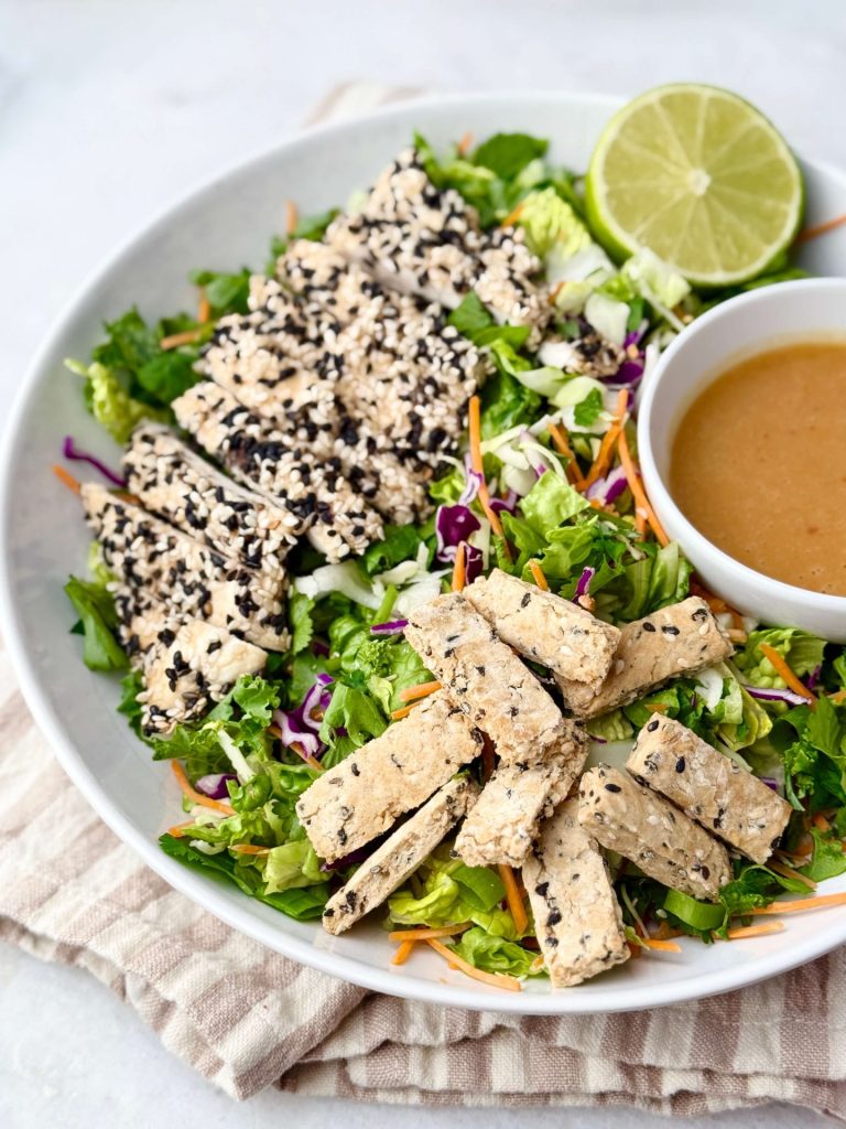 Close-up of the Erewhon Asian Chicken Salad recipe served in a wide bowl with vibrant greens, crunchy sesame sticks, and tangy dressing.