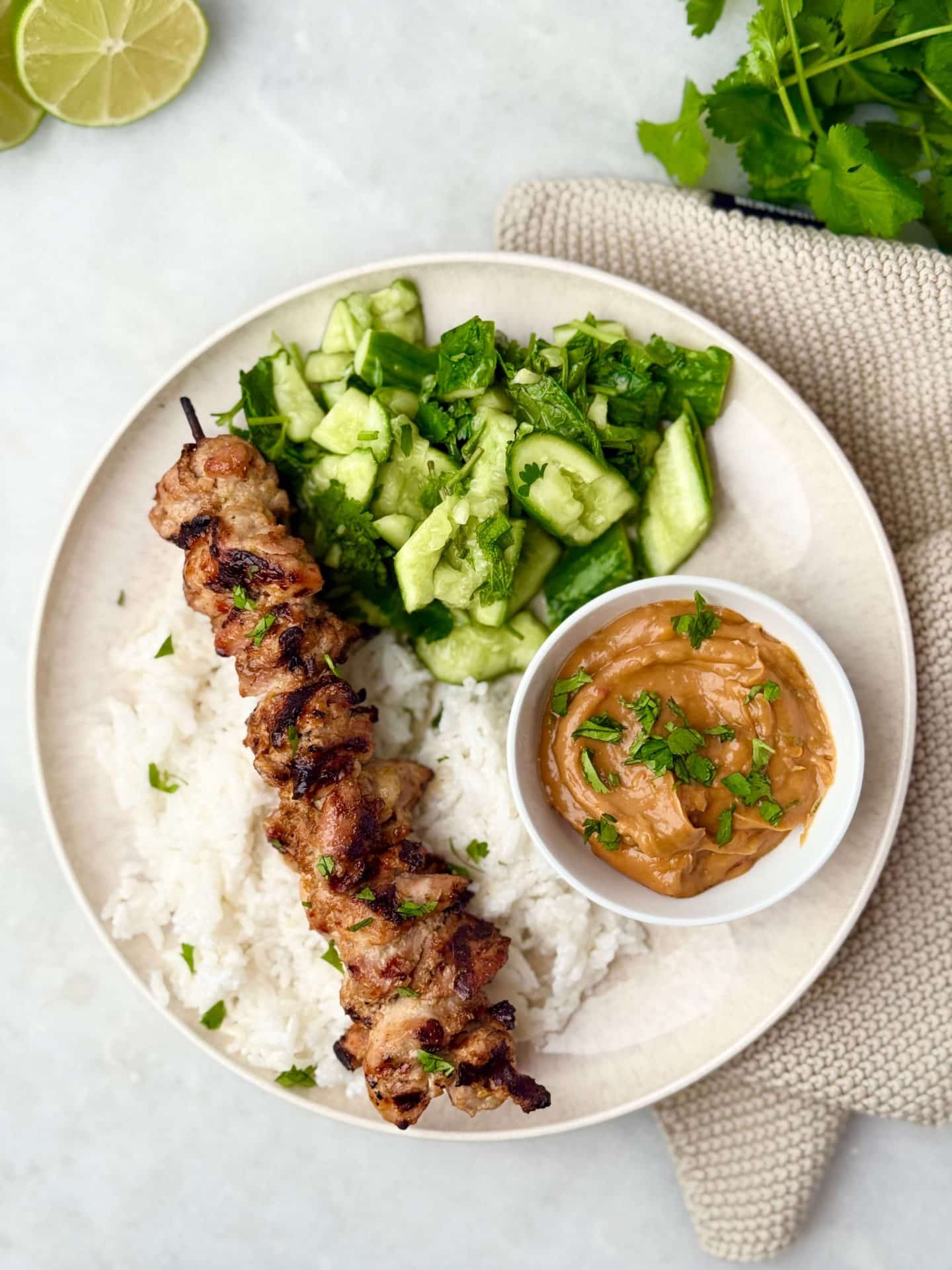 Healthy Indonesian satay skewers with creamy peanut dipping sauce and herb-packed cucumber salad.