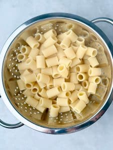 Drained rigatoni pasta in a colander.
