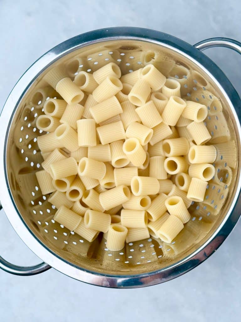 Drained rigatoni pasta in a colander.