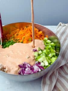 Creamy buffalo salad dressing poured over chopped vegetables and shredded chicken for an easy buffalo chicken salad recipe.