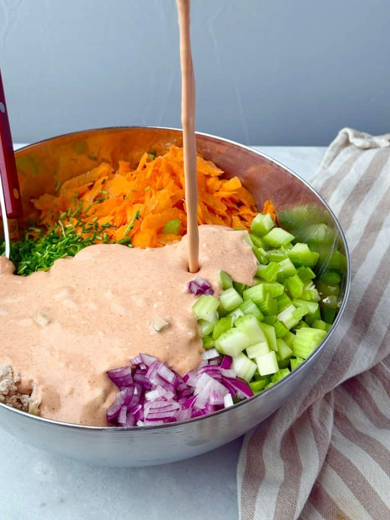 Creamy buffalo salad dressing poured over chopped vegetables and shredded chicken for an easy buffalo chicken salad recipe.