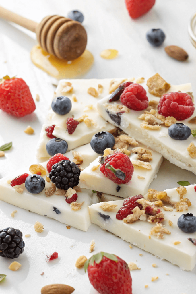 Frozen Greek yogurt bark topped with fresh berries, granola, and a drizzle of honey, a refreshing high-protein snack.